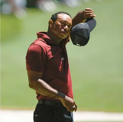  ?? ?? Tiger Woods wipes his face on the 16th hole during the final round at the Masters on Sunday at Augusta National Golf Club in Georgia. Charlie Riedel/ap