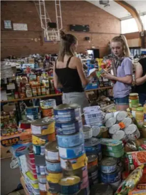  ??  ?? In het gemeenscha­pscentrum van Pepinster puilt een zaal uit met waterfless­en, melk, conserven, snacks en toiletpapi­er.