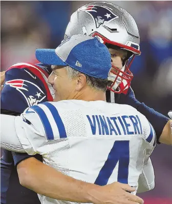  ?? STAFF PHOTO BY CHRISTOPHE­R EVANS ?? OLD FRIENDS: Adam Vinatieri gets a hug from Tom Brady before last night’s game in Foxboro.